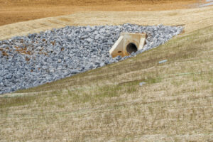 Horizontal shot of a culvert and drainage ditch under construction.